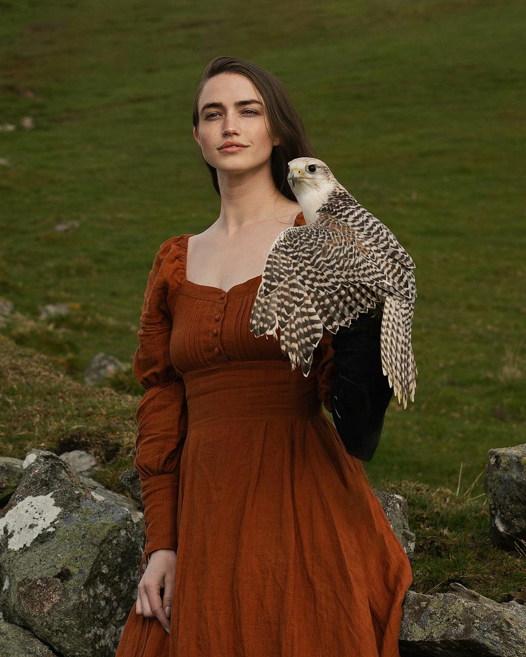 model in retro dress posing with falcon